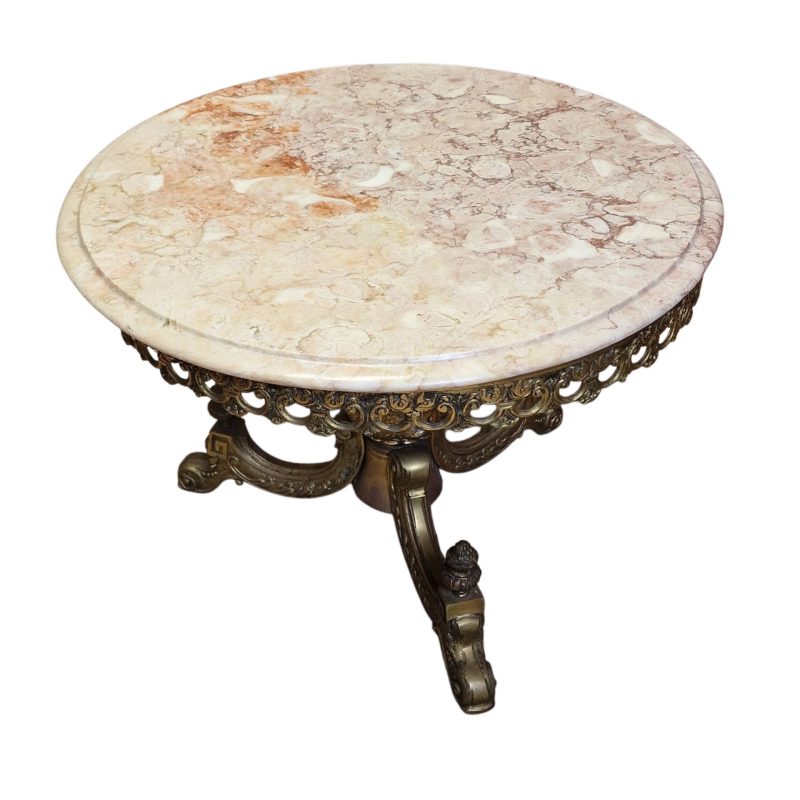 Mesa de centro redonda com tampo em pedra e base metálica decorada
